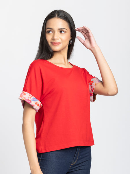 Right side profile of red Thea scoop neck t-shirt showing curved hemline and contrast printed sleeve design
