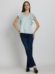 Model posing in Rufina Top and jeans showing short flared sleeves curved hem and luxurious satin drape