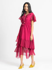 Side profile of dark pink Sebastina Dress showing flared sleeves tie up neckline and flowing asymmetric hem