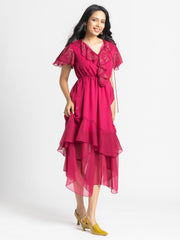 Model posing happily in Sebastina Dress highlighting ruffle details flared sleeves and relaxed fit silhouette