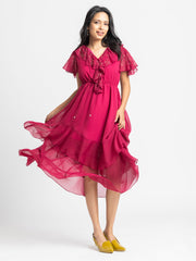 Model twirling in dark pink midi dress showing asymmetric hem and lightweight chiffon fabric with elegant drape