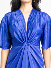 Close-up on twisted bodice, front embroidery, V-neck, and satin fabric texture of blue draped dress