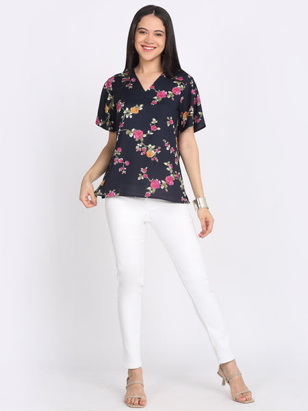 Full body view navy blue floral print viscose rayon v-neck top styled with white pants relaxed fit