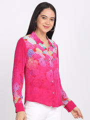 Pink floral shirt, shirt collar, long sleeves, relaxed fit, and white pants—left three-quarter angle