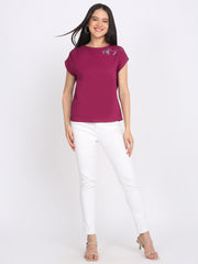 Full body styled image of purple embroidered crepe top with boat neck, drop shoulder sleeves, relaxed fit