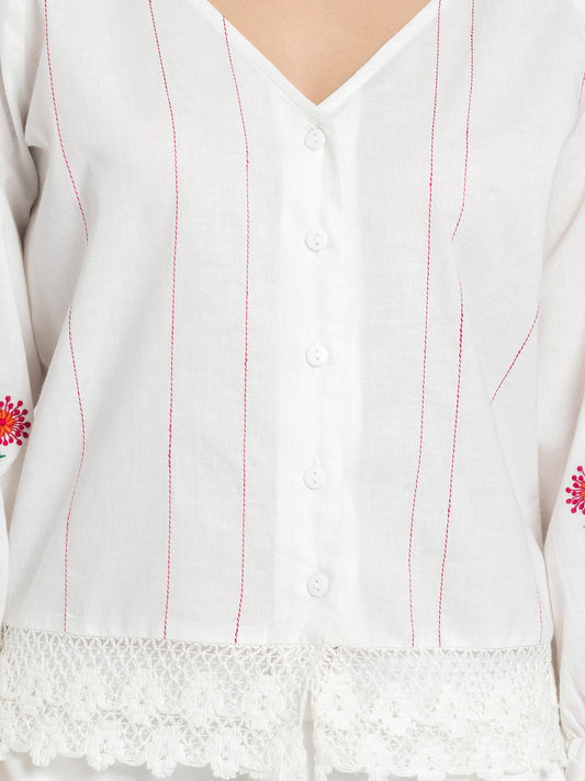 Close up of tagaai stitch detail on front and embroidery on sleeves of white Sojourn Co-ord crop top
