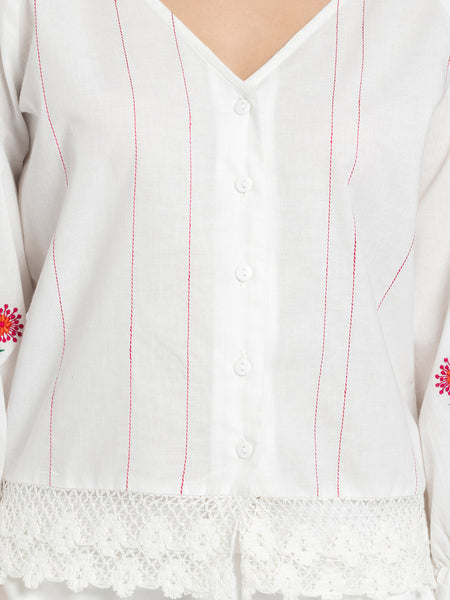 Close up of tagaai stitch detail on front and embroidery on sleeves of white Sojourn Co-ord crop top