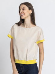 Model standing casually wearing beige boat neck Sullivan Top with rib detailing and relaxed fit