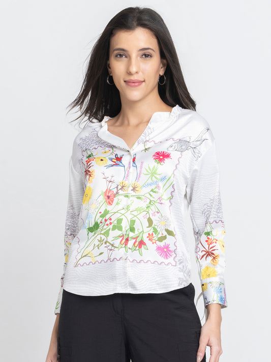 Model wearing Ursula Top with white floral print V-neck full sleeves button down front and relaxed fit curved hem