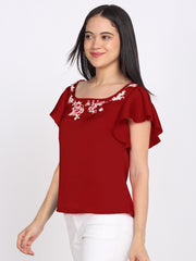 Side angle view maroon embroidered satin top with square neck, floral embroidery, and short flared sleeves