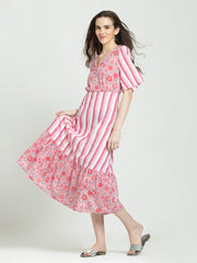 Model twirling in pink cotton fit and flare dress, floral print, flared hem, flowy look