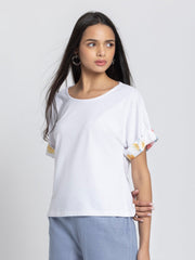 Left side view of white jersey knit t-shirt featuring drop shoulder sleeves and relaxed fit design